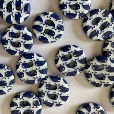 Pattern of blue and white buttons with whale design on a beige background