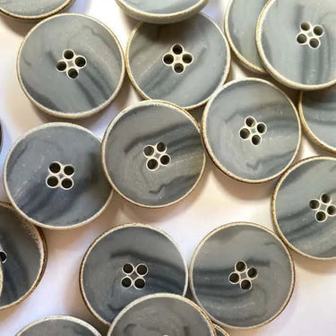 Collection of gray buttons with gold edges on a white background