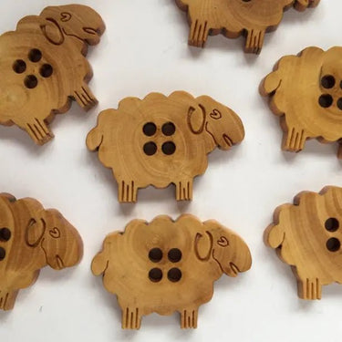 30mm Wooden Sheep Button (K4) made of natural wood, 30mm x 20mm, design features a sheep shape with four buttonholes.