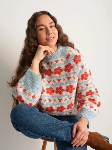 Woman wearing a colorful knitted sweater, featured in the 52 Weeks of Sweaters book.