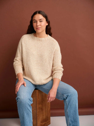 Person wearing a cozy knitted sweater, featured in '52 Weeks of Sweaters' knitting book, now available for pre-order.