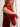 Woman adjusting red sweater from the book 52 Weeks of Sweaters