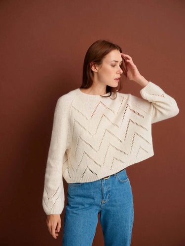 Woman modeling a knitted sweater from the 52 Weeks of Sweaters book, available for pre-order, with chevron pattern on brown background.
