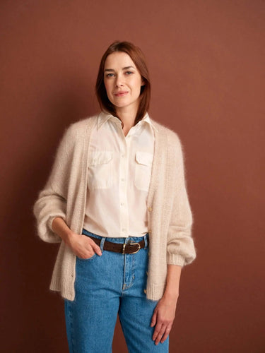 Model wearing a cozy cardigan featured in 52 Weeks of Sweaters knitting book, available for pre-order.