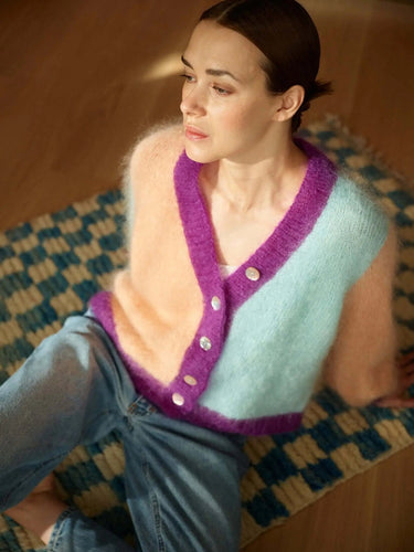 Model wearing colorful sweater featured in the 52 Weeks of Sweaters knitting book, pre-order available for Feb 19th 2026 release.