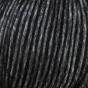Snefnug yarn close-up showcasing black and white fibers, made from baby alpaca, merino wool, and organic cotton.