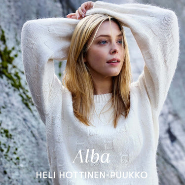 Woman wearing a cozy white sweater outdoors, promoting Archipelago Knitting pre-order.