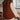 Person wearing a brown knitted vest in a kitchen setting