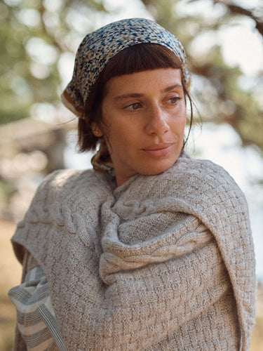Woman wearing knitted shawl featured in Laine Magazine Spring 28 issue.