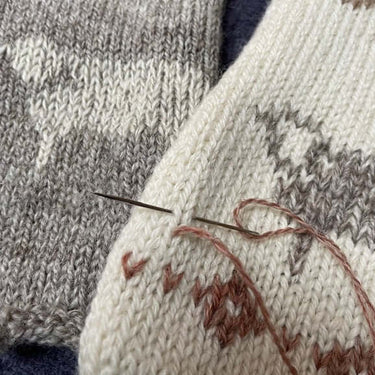 Needle threading Duplicate Stitch on knitted fabric in workshop with Justine Lee.