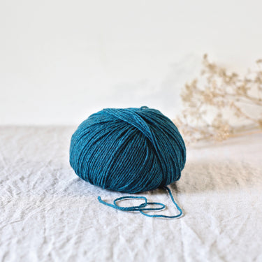 Gilliatt yarn ball in teal, made from French Mérinos d'Arles and black Portuguese merino, showcasing its fluffy texture and stitch definition.
