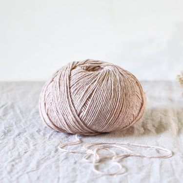 Ball of yarn on a textured surface with a light background