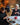 Two women sitting at a table in a cozy café, both knitting