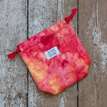 Ice Dyed Project Knitting Bag - Small by Josie Rose with vibrant red and orange design on wooden background.