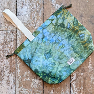 Ice Dyed Project Bags - XLarge with unique blue-green pattern, cotton fabric, and strap on wooden floor.