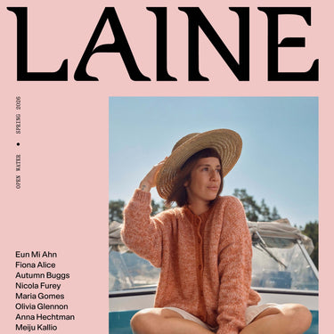 Cover of Laine Magazine Spring Issue 28 featuring a woman in a hat and knitted sweater on a boat.