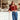 Woman in a red sweater and blue jeans standing in a cafe.