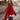 Person wearing a red sweater standing outdoors with blurred background