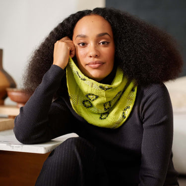 Model wearing a vibrant handmade scarf with intricate Beaded Colourwork, showcasing modern knitting techniques with beads by Jeanette Sloan.