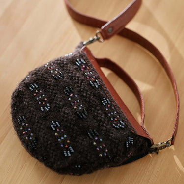 Stylish purse showcasing Beaded Colourwork design on wooden surface