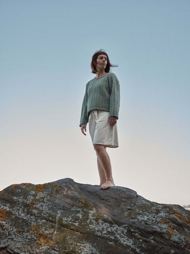 Model in knitwear from Laine Magazine Spring 28 on rocky landscape