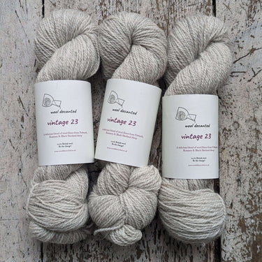 Three skeins of Wool Decanted Vintage 23 4ply Yarn in light grey, known for its next to skin softness, perfect for knitting.