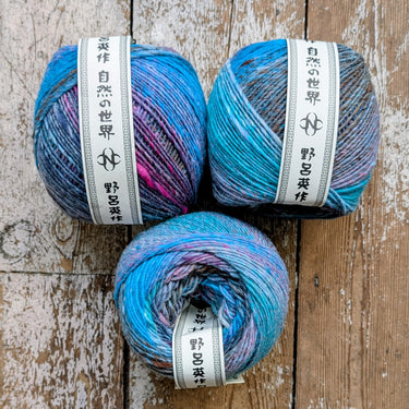 Ito worsted weight yarn in colorful blue and pink skeins from Noro, showcasing slubby texture and vibrant color spectrum for knitting.