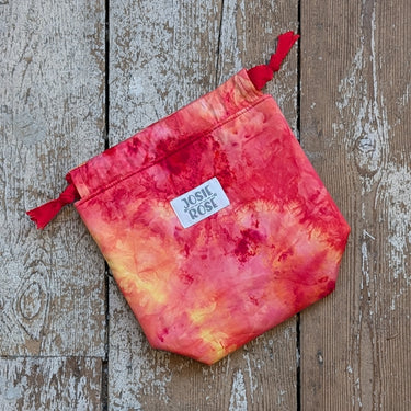 Ice Dyed Project Knitting Bag - Small by Josie Rose with vibrant red and orange design on wooden background.