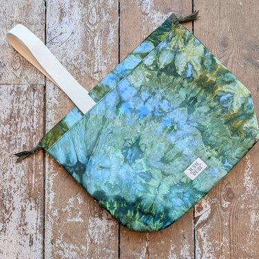 Ice Dyed Project Bags - XLarge with unique blue-green pattern, cotton fabric, and strap on wooden floor.