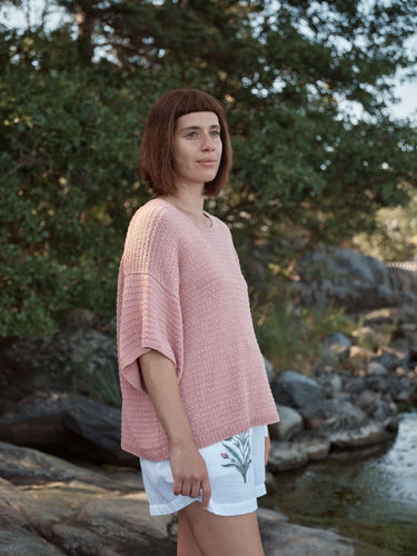 Woman wearing a pink sweater outdoors, featured in Laine Magazine Spring 28 pre-order.
