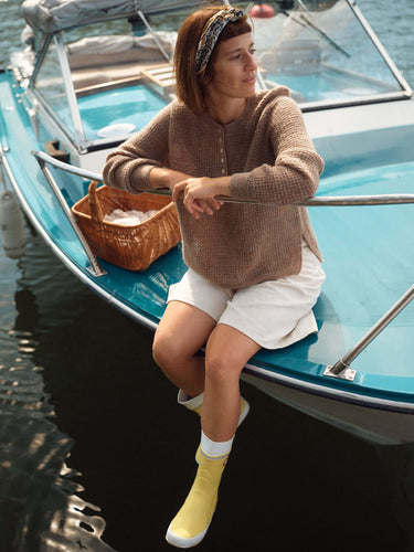 Woman on boat in spring wearing knitwear from Laine Magazine bright spring day