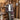 Person standing in a rustic wooden interior with a striped shawl. Tukubook knitting book
