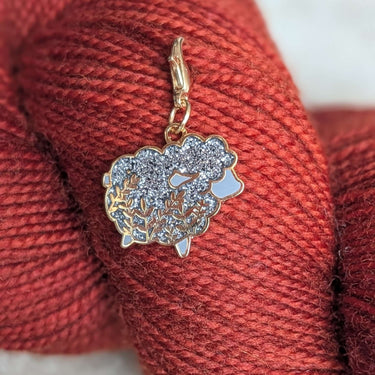 Twill + Print Progress Keepers with silver sheep charm on red yarn for knitting and crochet projects.