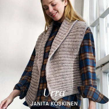 Woman wearing a beige knitted vest over a plaid shirt, standing by a window. Text reads Urra Janita Koskinen.