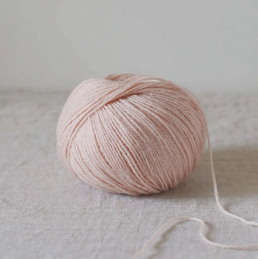 Alice | De Rerum Natura yarn ball with 75% organic Merino d'Arles wool and 25% linen blend, displaying soft texture and natural color.