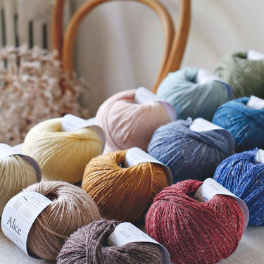 Alice | De Rerum Natura yarn skeins in various colors showcasing organic Mérinos d'Arles and linen blend with great fineness and softness.