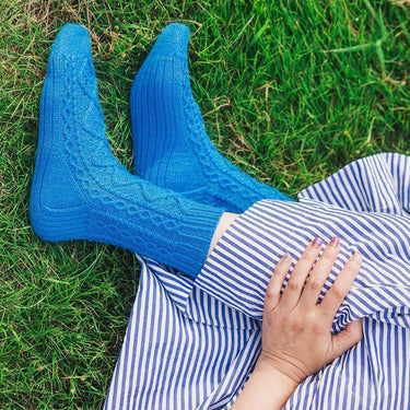 Person wearing blue knitted socks from Amirisu Sock Knitting Club