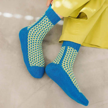 Blue and yellow designed socks from Amirisu Sock Knitting Club collection, showcasing intricate patterns.