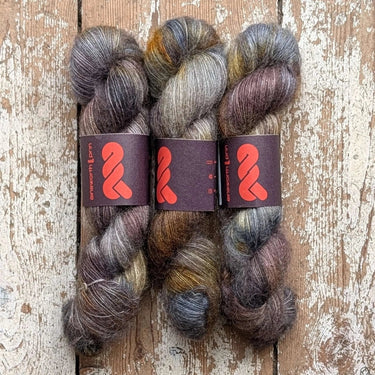 Ainsworth & Prin Lace Silk Mohair yarn skeins in unique hand dyed colors on rustic wooden background.