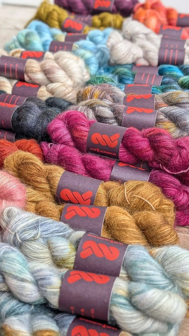 Variety of hand dyed A&P Lace Silk Mohair skeins in vibrant colors, showcasing their luxurious fluffy texture.