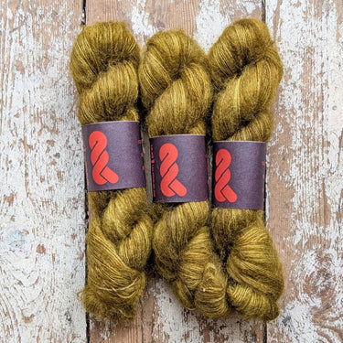 Lace Silk Mohair yarn in rich golden green hues, perfect for adding softness and elegance to your knitting projects.