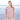 Model wearing a textured sweater from Aran by Marie Wallin collection on a beach background
