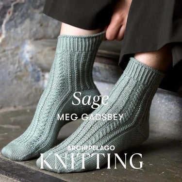 Archipelago Knitting pre-order featuring stylish grey knit socks in cable pattern on feet.