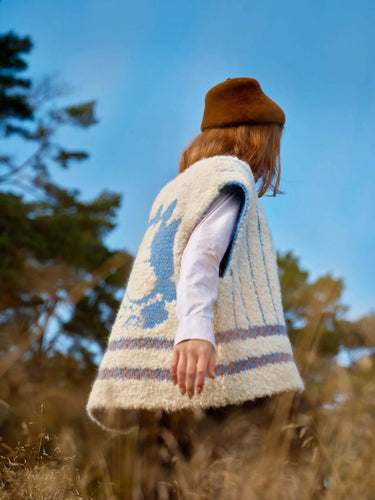 Model wearing knitwear from Art of the Sea collection by Laine, featuring Moomins-inspired design in nature setting.