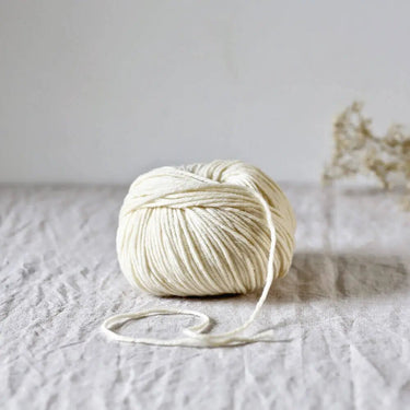Cyrano soft white yarn ball made from carded French Arles merino and Portuguese black wool, perfect for knitting and crochet projects.