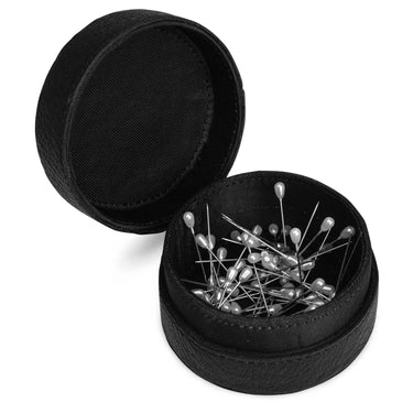 Black round container with sewing pins on a white background