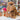 Inkari Stuffed Alpaca Animal in Monsterfluff style, brown color, displayed on a shop counter with yarn background.