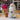 Inkari Stuffed Alpaca Animal in natural color with fluffy texture, displayed beside colorful yarn and decorative vase.