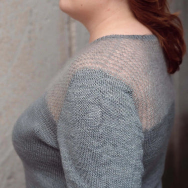 Woman wearing a light blue knitted sweater against a neutral background