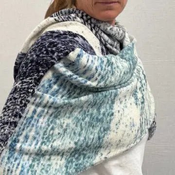 Woman wearing a knitted blue and white wrap made with Yarn Advent Calendar skeins